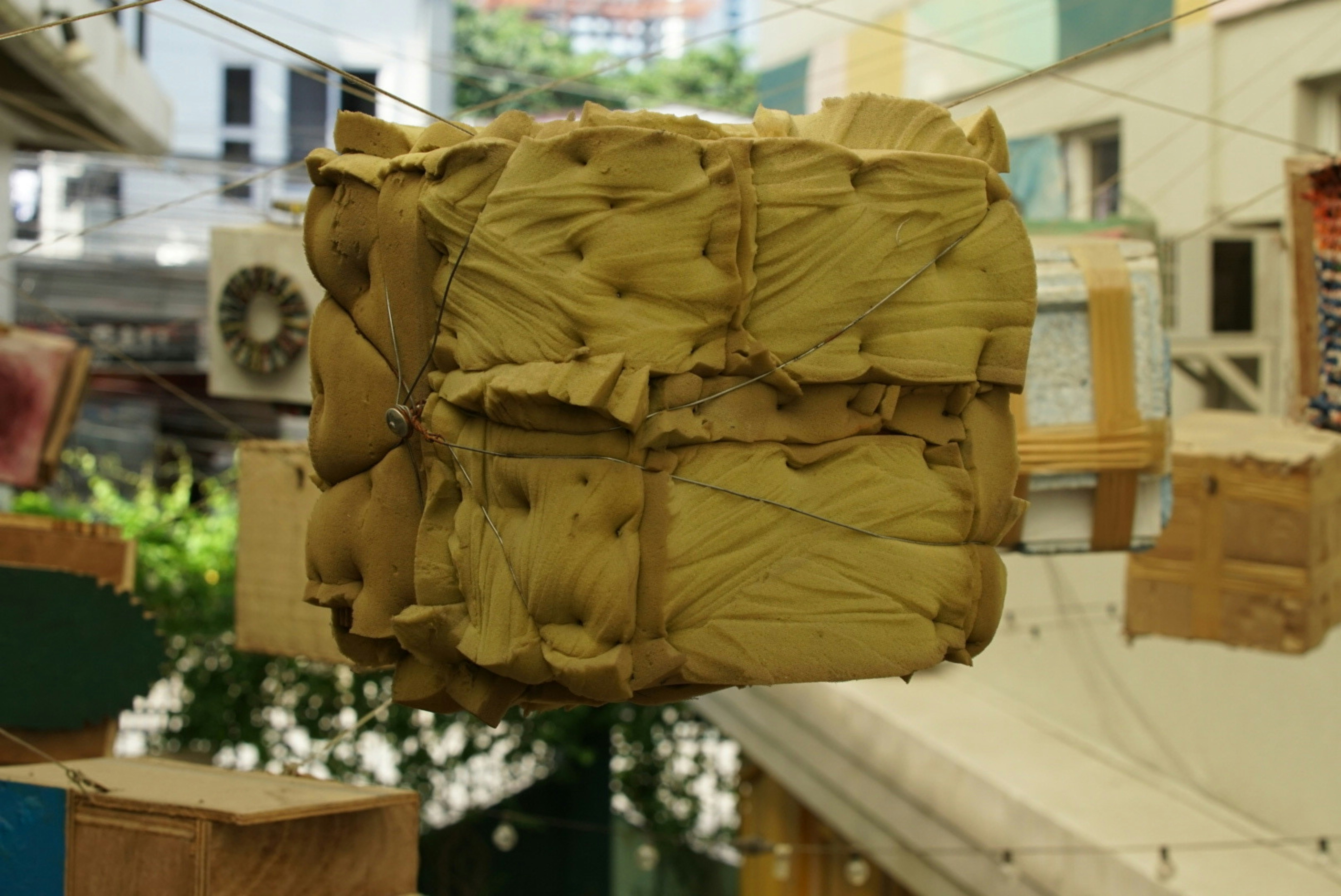 A large, square, yellow object hanging outdoors.